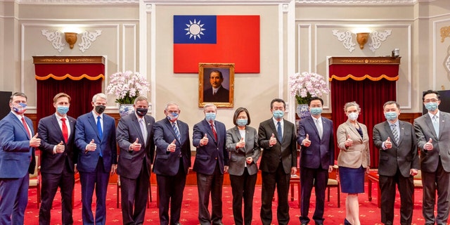 In this photo released by the Taiwan Presidential Office, members of an American congressional delegation, from left, Rep. Ronny Jackson, R-Texas; Sen. Ben Sasse, R-Neb.; Sen. Rob Portman, R-Ohio; Sen. Richard Burr, R-N.C.; Sen. Bob Menendez, D-N.J.; and Sen. Lindsey Graham, R-S.C., pose for a photo with Taiwan's President Tsai Ing-wen, center right, and other Taiwanese officials during a meeting at the Presidential Office in Taipei, Taiwan, Friday, April 15, 2022. 