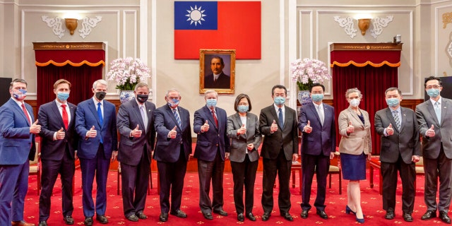 In this photo released by the Taiwan Presidential Office, members of an American Congressional delegation, from left, Rep. Ronny Jackson, R-Texas, Sen. Ben Sasse, R-Neb., Sen. Rob Portman, R-Ohio, Sen. Richard Burr, R-N.C., Sen. Bob Menendez, D-N.J., and Sen. Lindsey Graham, R-S.C., pose for a photo with Taiwan's President Tsai Ing-wen and Taiwanese officials.