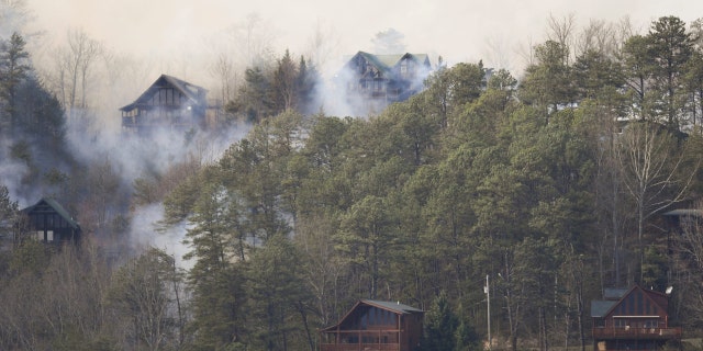 Smoke surrounds cabins as they begin to burn from the Wears Valley wildfire in Sevierville, Tennessee on March 30, 2022.