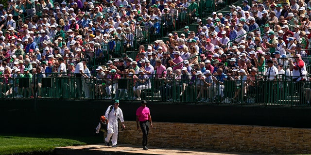 Tiger Woods walks across the Serazen Bridge on the 15th hole during the first round at the Masters golf tournament on Thursday, April 7, 2022, in Augusta, Georgia. (AP Photo/David J. Phillip)