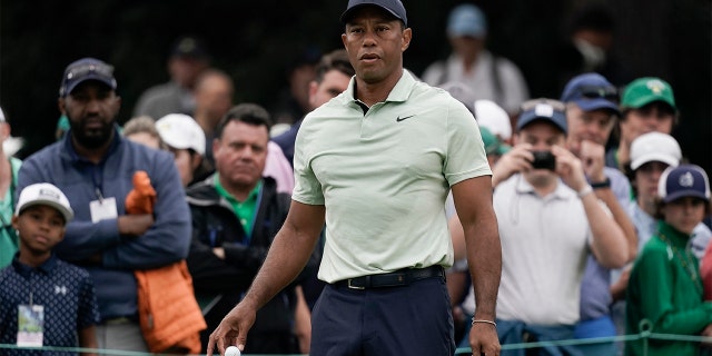 Tiger Woods drops golf balls on the driving range during a practice round for the Masters golf tournament on Tuesday, April 5, 2022, in Augusta, Ga.