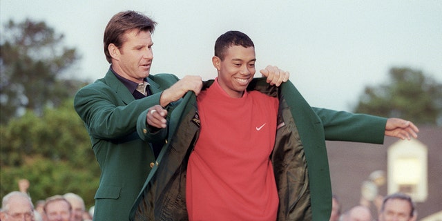 Tiger Woods receives the Masters green jacket from 1996 Masters champion Nick Faldo after Woods won the 1997 Masters tournament at Augusta National Golf Club in Georgia.