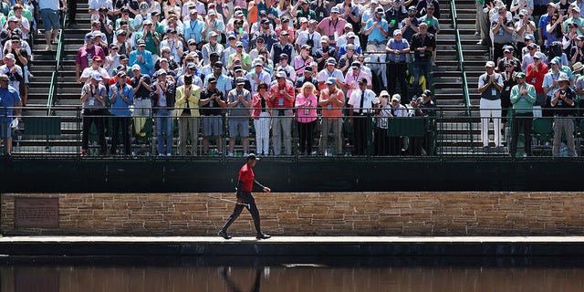 Tiger Woods walks across the Sarazen Bridge to reach the 15th green during the final round of the Masters at Augusta National Golf Club on April 10, 2022 in Augusta, Georgia.