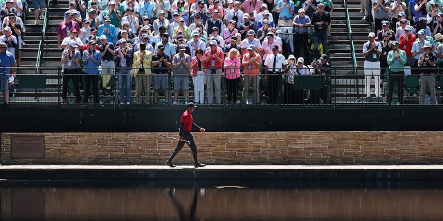 Tiger Woods walks across the Sarazen Bridge to reach the 15th green during the final round of the Masters at Augusta National Golf Club on April 10, 2022 in Augusta, Georgia.