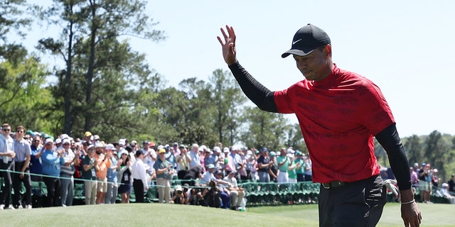 Tiger Woods waves to the crowd on the 18th green after finishing his round during the final round of the Masters at Augusta National Golf Club on April 10, 2022 in Augusta, Georgia.