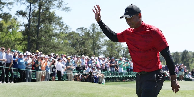 Tiger Woods waves to the crowd on the 18th green after finishing his round during the final round of the Masters at Augusta National Golf Club on April 10, 2022 in Augusta, Georgia.