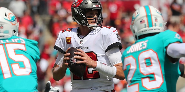 Tampa Bay Buccaneers Quarterback Tom Brady (12) looks for an open receiver during the regular season game between the Miami Dolphins and the Tampa Bay Buccaneers on Oct. 10, 2021 在坦帕的雷蒙德詹姆斯体育场, 佛罗里达.
