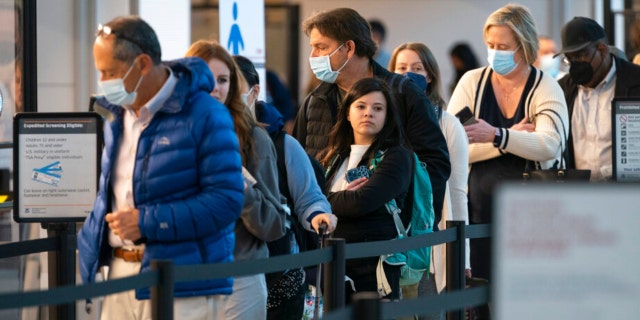 Passengers wait in line at the security checkpoint at Ronald Reagan Washington National Airport, Tuesday, April 19, 2022, in Arlington, Virginia.