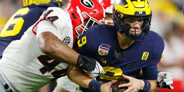 Travon Walker #44 of the Georgia Bulldogs attempts to tackle J.J. McCarthy #9 of the Michigan Wolverines in the fourth quarter in the Capital One Orange Bowl for the College Football Playoff semifinal game at Hard Rock Stadium on December 31, 2021 in Miami Gardens, Florida.