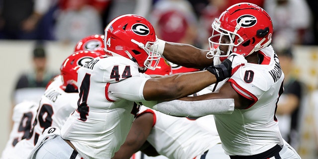 Travon Walker #44 Darnell Washington #0 of the Georgia Bulldogs warm up prior to a game against the Alabama Crimson Tide in the 2022 CFP National Championship Game at Lucas Oil Stadium on January 10, 2022, in Indianapolis, Indiana.