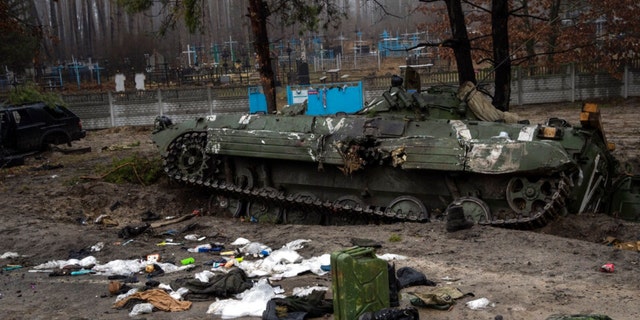 Military gear left behind by Russian soldiers lay scattered near a tank during a military sweep by Ukrainian soldiers after the Russians' withdrawal from the area on the outskirts of Kyiv, Ukraine, Friday, April 1, 2022. 