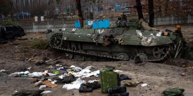 Military gear left behind by Russian soldiers lay scattered near a tank during a military sweep by Ukrainian soldiers after the Russians' withdrawal from the area on the outskirts of Kyiv, Ukraine, Friday, April 1, 2022. 