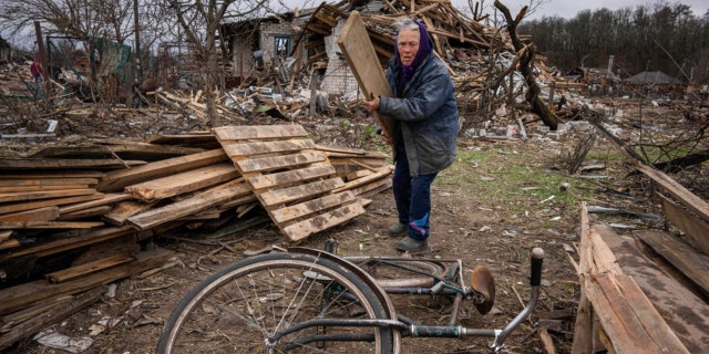 A woman collecting wooden planks in a street destroyed by shellings in Chernihiv, Ukraine, April 13.