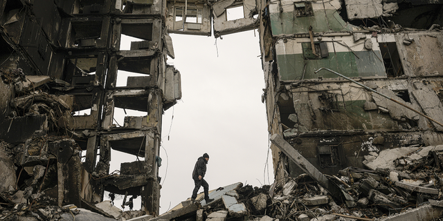 A resident looks for belongings in an apartment building destroyed during fighting between Ukrainian and Russian forces in Borodyanka, Ukraine.