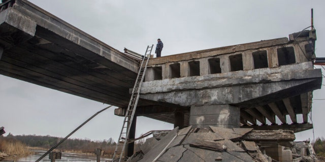 Un militar ucraniano se encuentra en un puente destruido entre el pueblo de Dytiatky y Chernobyl, Ucrania, el 5 de abril de 2022. 