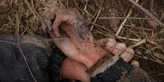 The body of Anton Ischenko, 20, a Ukrainian man who died while his village was occupied by Russian troops, lies in a field in Andriivka, Ukraine, Tuesday, April 5, 2022.