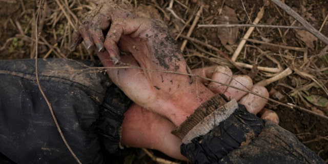 The body of Anton Ischenko, 20, a Ukrainian man who died while his village was occupied by Russian troops, lies in a field in Andriivka, Ukraine, Tuesday, April 5, 2022.