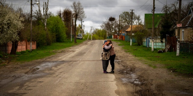 Tetyana Boikiv, 52, right, meets and hugs her neighbor Svitlana Pryimachenko, 48, during a funeral service for her husband, Mykola Moroz, 47, at the Ozera village, near Bucha, Ukraine, April 26, 2022. Mykola was captured by the Russian army from his house in the Ozera village March 13, taken for several weeks to an unknown location and finally found killed with gunshot wounds about 15 kilometers from his house. 