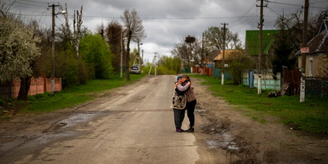 Tetyana Boikiv, 52, right, meets and hugs her neighbor Svitlana Pryimachenko, 48, during a funeral service for her husband, Mykola Moroz, 47, at the Ozera village, near Bucha, Ukraine, April 26, 2022. Mykola was captured by the Russian army from his house in the Ozera village March 13, taken for several weeks to an unknown location and finally found killed with gunshot wounds about 15 kilometers from his house.