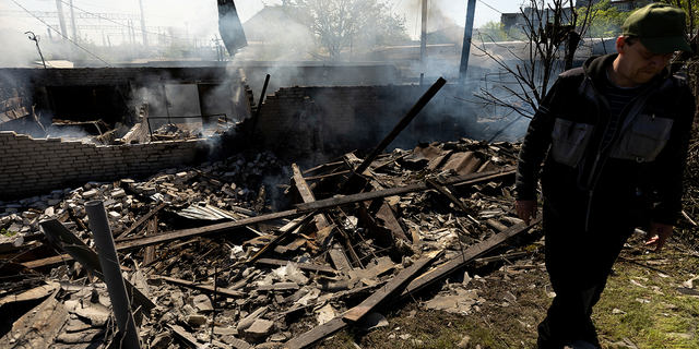 A man stands at the site of a destroyed garage following a military strike near a railway station in Lyman, in the Donetsk region of Ukraine, on Thursday, April 28.