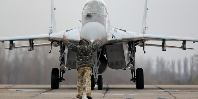 A ground officer operates a MiG-29 fighter jet of the Ukrainian Air Force during a training session at a military air base near Kyiv, November 2016.