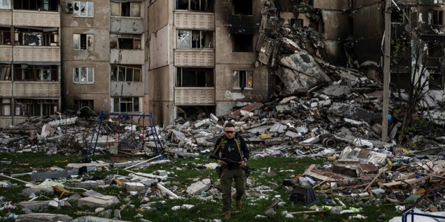 A Ukrainian military man walks among the rubble of a building badly damaged by numerous Russian bombings near a front line in Kharkiv, Ukraine on Monday, April 25, 2022. 