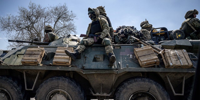 Ukrainian military personnel in an armored personnel carrier drive down a highway outside Kriviil, as Russia launches a military invasion of Ukraine on April 28, 2022.  (Photo by ED JONES/AFP via Getty Images)