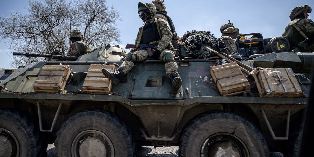 Ukrainian servicemen ride on an armored personnel carrier on the outskirts of Kryvyi Rih on Thursday, April 28.