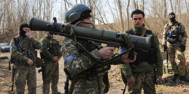 Ukrainian servicemen study a Sweden shoulder-launched weapon system Carl Gustaf M4 during a training session on the near Kharkiv, Ukraine, April 7, 2022. 