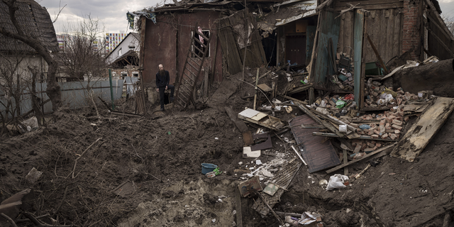 Oleg Mezhiritsky stands outside his house, damaged after a Russian attack in Kharkiv, Ukraine, on Friday.  