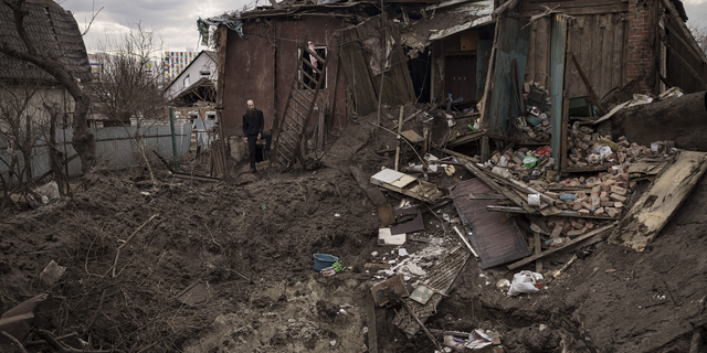 Oleg Mezhiritsky stands outside his house, damaged after a Russian attack in Kharkiv, Ukraine, on Friday.