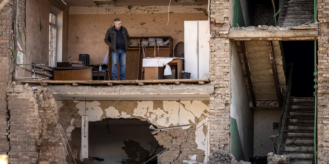 A man stands in a building at the missile factory that the Russian military claims to have hit in kyiv.