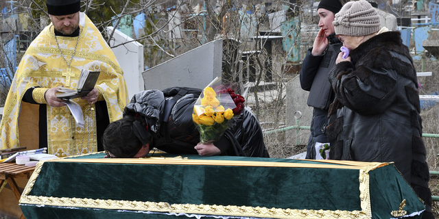 Relatives and friends stand near the coffin of Ukrainian serviceman Anatoly German during a funeral ceremony in Kramatorsk, Ukraine. 