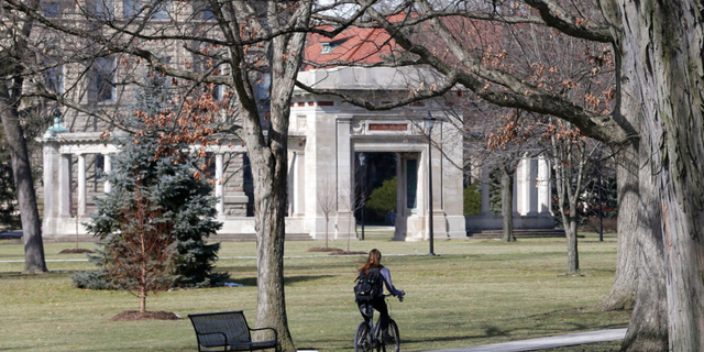 This March 5, 2013, file photo shows a student riding a bicycle on the campus of Oberlin College in Oberlin, Ohio. The 9th District Court of Appeals upheld a $31 million judgment March 31, 2022 against Oberlin College that had been awarded to Gibson's Bakery and Food Mart, which successfully claimed it was libeled by the school after a shoplifting incident in November 2016.   