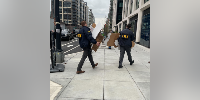 Federal law enforcement agencies enter an apartment building in Washington, D.C.
