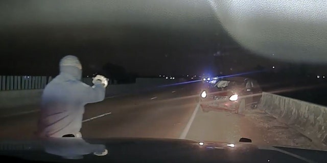 A law enforcement officer approached a car near Memphis, Tennessee, after a police chase April 17, 2022, in this image from video released by the West Memphis Police Department.