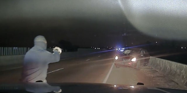 A law enforcement officer approached a car near Memphis, Tennessee, after a police chase April 17, 2022, in this image from video released by the West Memphis Police Department.