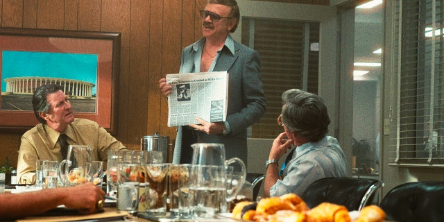 This image released by HBO shows Brett Cullen, portraying Bill Sharman, left, and John C. Reilly, portraying Jerry Buss, standing, in a scene from the series