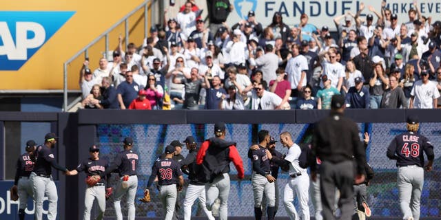 Members of the Cleveland Guardians react after fans threw debris on the field after New York Yankees' Gleyber Torres #25 left the RBI single late in the ninth inning, April 23, 2022 in New York, New York.