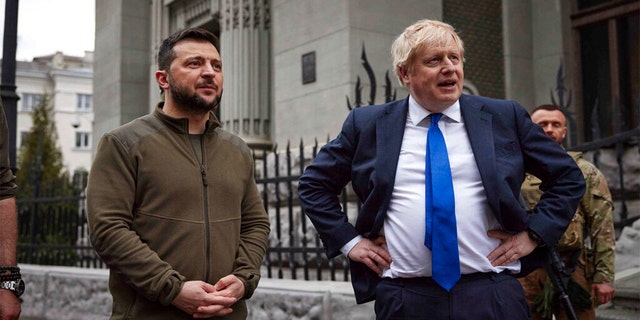 In this image provided by the Ukrainian Presidential Press Office, Ukrainian President Volodymyr Zelenskyy, left, and Britain's Prime Minister Boris Johnson talk during their walk in downtown Kyiv, Ukraine, Saturday, April 9, 2022.