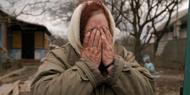 Tetiana Oleksiienko cries as she stands at the gate of her house in the village of Andriivka, Ukraine, which was heavily affected by fighting between Russian and Ukrainian forces, on Wednesday, April 6, 2022. 