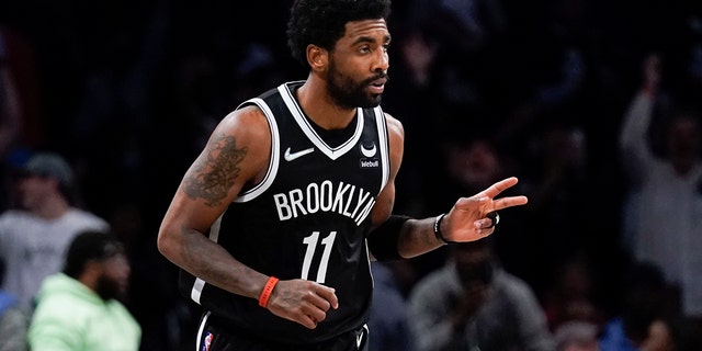 The Brooklyn Nets' Kyrie Irving reacts after hitting a basket against the Cleveland Cavaliers during the first half of the NBA play-in tournament April 12, 2022, in New York.