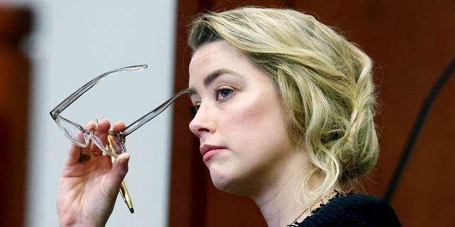 Actor Amber Heard listens in court at the Fairfax County Circuit Court in Fairfax, Virginia, Thursday, April 28, 2022. Actor Johnny Depp sued his ex-wife, actress Amber Heard, for defamation in Fairfax County Court after she wrote an opinion-administrative article in a newspaper The Washington Post in 2018 refers to itself as a "A public figure representing domestic violence." 