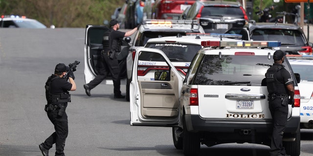 Metropolitan Police point their weapons at a building Van Ness Street Northwest toward the scene of shooting on April 22, 2022, in Washington, DC.