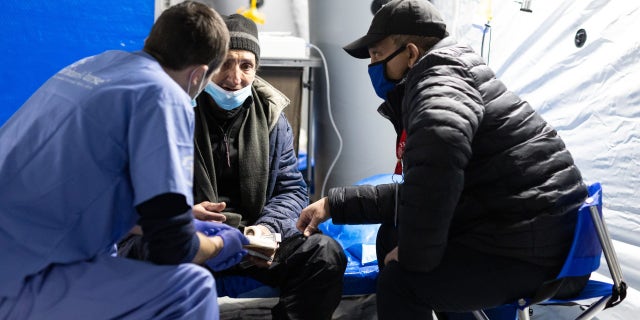 Volunteers tend to an injured and displaced Ukrainian man amid the war. 