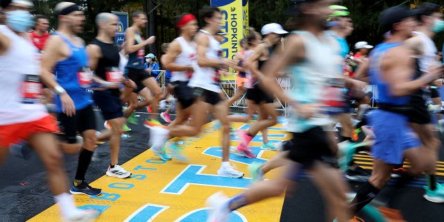 Runners cross the starting line of the 125th Boston Marathon, Monday, Oct. 11, 2021, in Hopkinton, Massachusetts.