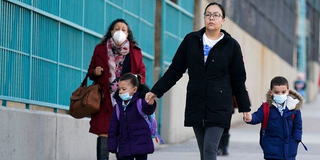 FILE - Children and their caregivers arrive for school in New York, Monday, March 7, 2022. COVID-19 hospitalization numbers have plunged to their lowest levels since the early days of the pandemic, offering a much needed break to health care workers and patients alike following the omicron surge. (AP Photo/Seth Wenig, File)