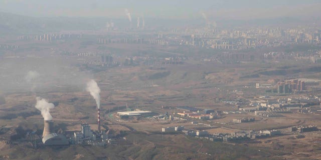 Smoke and steam rise from towers at the coal-fired Urumqi Thermal Power Plant as seen from a plane in Urumqi in western China's Xinjiang Uyghur Autonomous Region April 21, 2021.