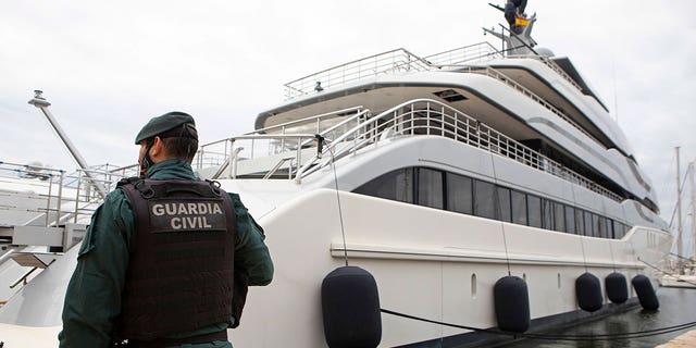 A Civil Guard stands by the yacht called Tango in Palma de Mallorca, Spain, Monday April 4, 2022. U.S. federal agents and Spain's Civil Guard are searching the yacht owned by a Russian oligarch. The yacht is among the assets linked to Viktor Vekselberg, a billionaire and close ally with Russia's President Vladimir Putin. (AP Photo/Francisco Ubilla)