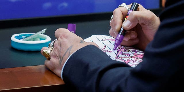 Actor Johnny Depp draws in a sketch pad during his defamation trial against ex-wife Amber Heard at the Fairfax County Circuit Courthouse in Fairfax, Va., April 27, 2022.